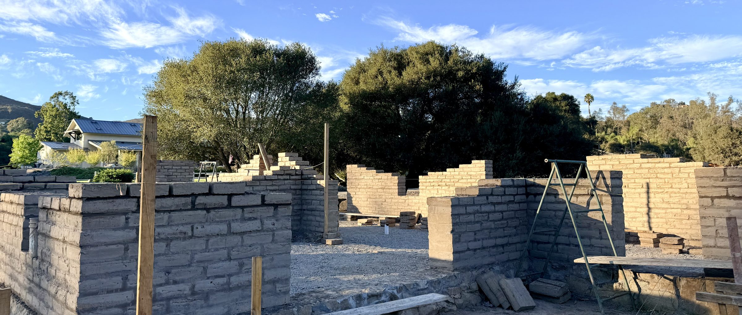 Adobe walls under construction on the knoll, 4 September 2026
